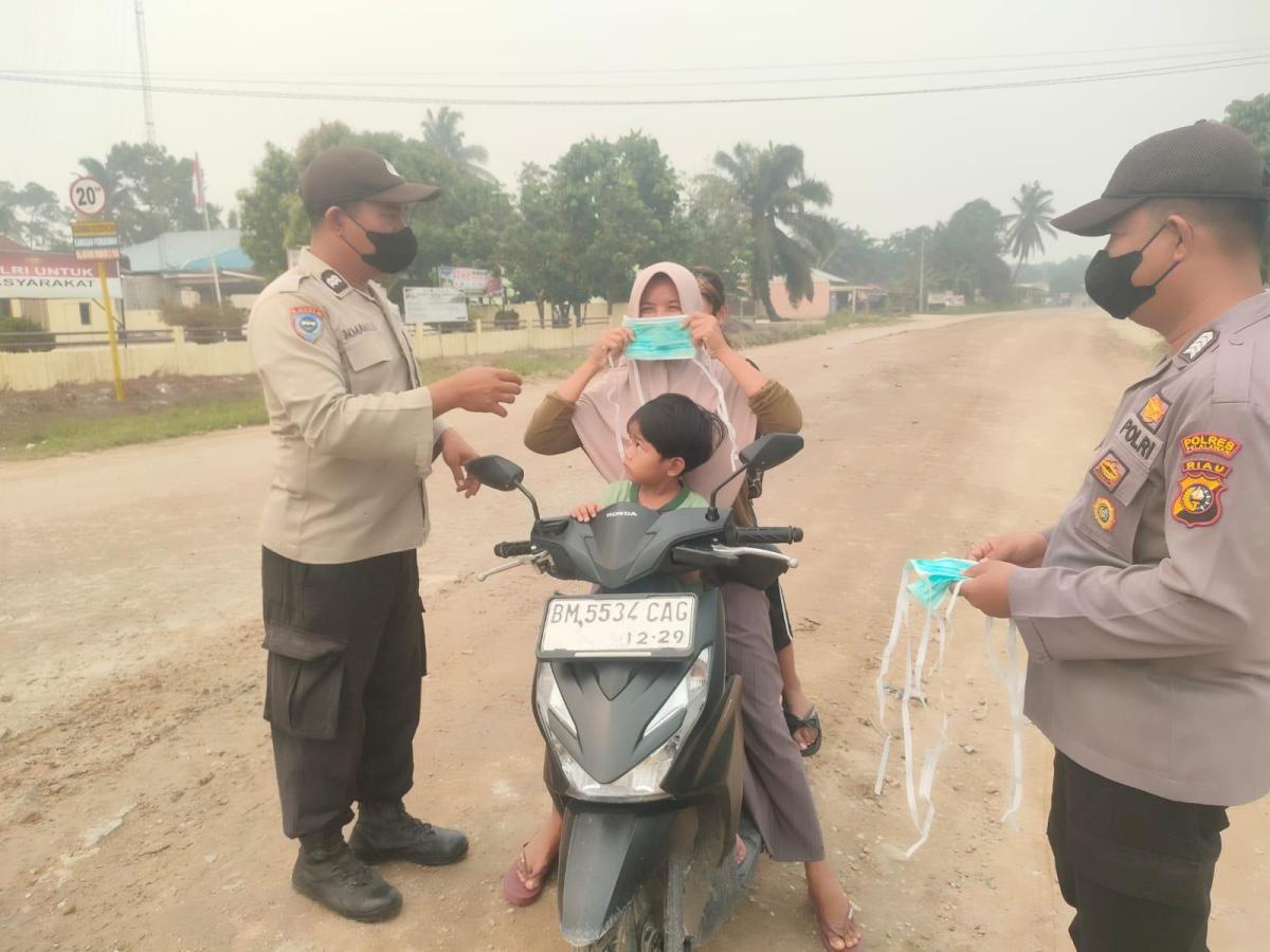 Peduli Warga Terdampak Asap Karhutla, Polsek Langgam Bagikan Masker